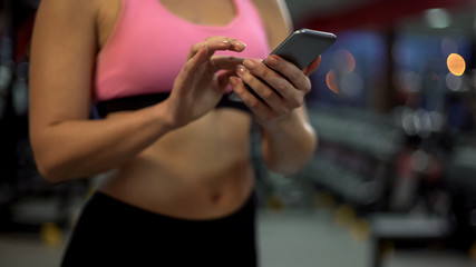 Sport woman watching fitness video on smartphone, health lifestyle information