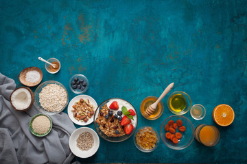 Ingredients for a healthy breakfast - granola, honey, nuts, berries, fruits, on blue background,