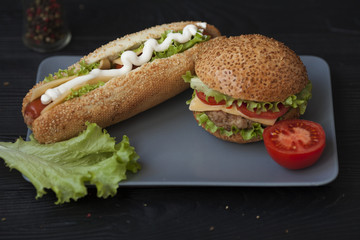 Hot dogs and hamburgers on the plate on wooden background. Street food. bistro Cafe