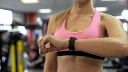 Fototapeta na wymiar Fit lady looking at sport bracelet indicators, pulse rate and workout duration