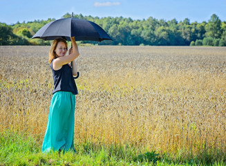 Portrait of woman with umbrella in field