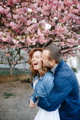 Obraz premium couple in love in a blooming Apple orchard lying on the blanket