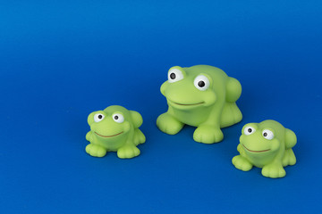 Ranas verdes sobre fondo azul.