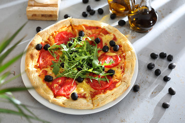 Pizza z pomidorami. Pizza z pomidorami, czarnymi oliwkami, rukolą.