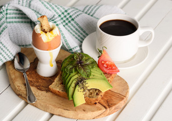 Sandwich with avocado and poached egg - healthy breakfast concept