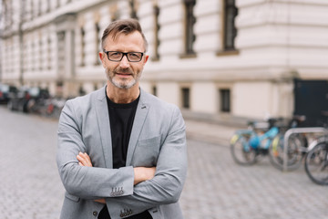 Thoughtful businessman standing staring at camera