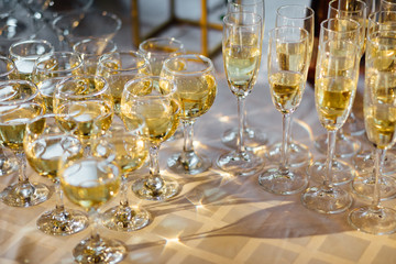 A lot of wine glasses with a cool delicious champagne or white wine at the bar. Alcohol background.