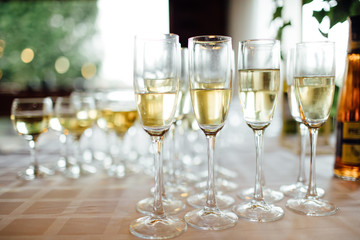 A lot of wine glasses with a cool delicious champagne or white wine at the bar. Alcohol background.