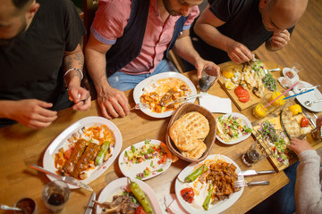 Arab people in restaurant enjoying a traditional Iftar dinner. View from above. Selective focus