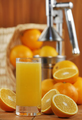 Orange juice on table on wooden background (selective focus)

