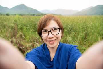 Asian woman taking a selfie with smartphone.