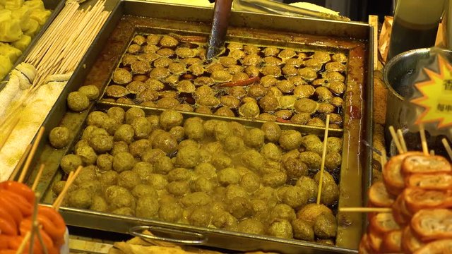 HONG KONG - CIRCA APRIL 2018 : CURRY FLAVORED FISH BALLS at street food shop.