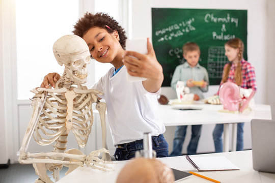 So funny. Cheerful nice boy taking selfies while having a biology class
