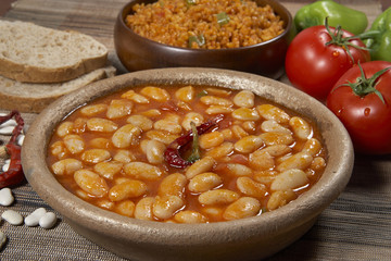 Dried beans,white beans in tomato sauce in bowl closeup. horizontal
