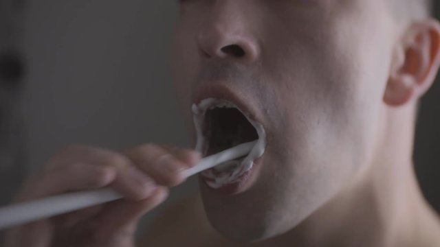 Man brushing his teeth in the morning and sings
