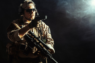 Special forces soldier with rifle on dark background