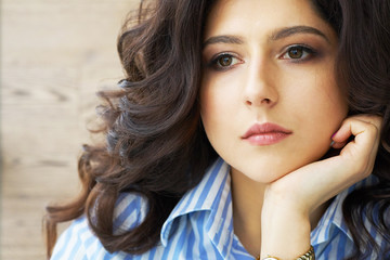 Girl with long curly hair. Perfect skin. Stylish gorgeous girl in the luxury beauty salon. Girl with long curly hair. Beautiful sexy girl with hair sitting near the window in the dressing room.