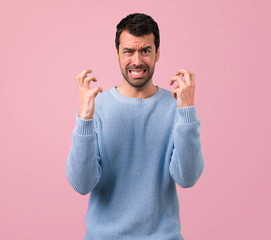 Fototapeta premium Handsome man annoyed angry in furious gesture on pink background