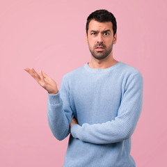 Handsome man unhappy and frustrated with something. Negative facial expression on pink background