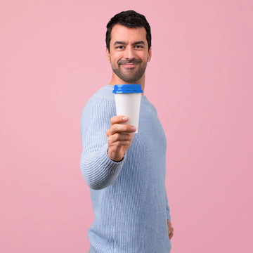 Man With Blue Sweater Holding Hot Coffee In Takeaway Paper Cup On Pink Background