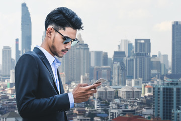 businessman in suit using smartphone at city