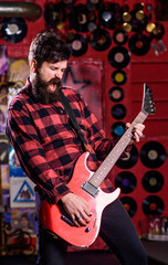 Obraz na płótnie Canvas Rock star concept. Musician with beard play electric guitar.