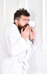 Hipster in bathrobe on suspicious face secretly listen conversation. Secret and spy concept. Man in...