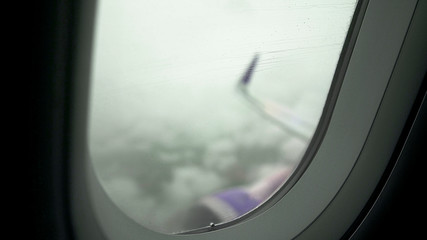 Naklejka premium Passenger airliner flying in low visibility rainy sky, high risk of accident