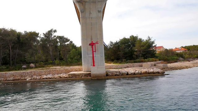 Going under the bridge Zdrelac between islands in Croatian Adriatic sea. Filmed on sailing trip in Croatia in slow motion hd.