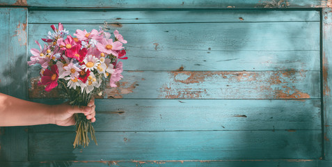 Obraz premium Ręka trzyma bukiet kwiatów