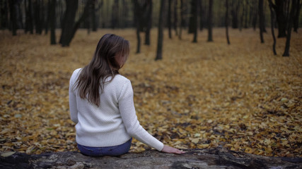 Sad woman sitting in autumn park remembering deceased husband, loss of loved one