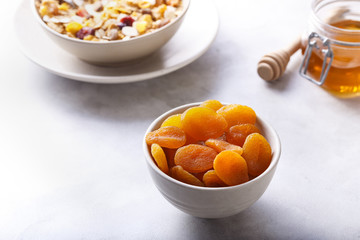 Dried Apricots In A Bowl. With Honey And Muesli. White Background.