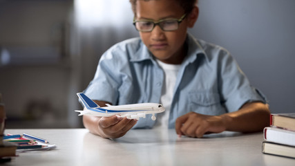 Boy dreaming of becoming pilot of modern airline and flying to faraway countries