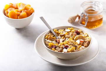 Muesli served with honey and dried apricots.