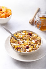Muesli served with honey and dried apricots.