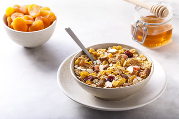 Muesli served with honey and dried apricots.