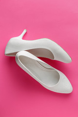 White wedding shoes on pink background