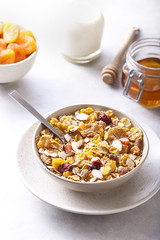 Muesli served with milk, honey and dried apricots.