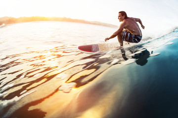 Surfer rides the glassy wave in tropics at sunrise. Costa Rica