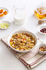 Muesli served with milk, grapes, almonds, dried apricots and dried cranberries