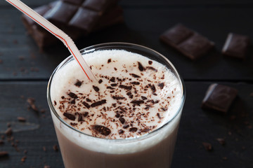Chocolate milk shake and chocolate crumbs on wooden backgr