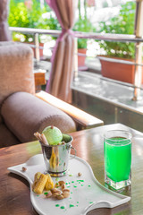 A bucket cup of pistachio ice cream topped with corn cones on white table in on the summer veranda