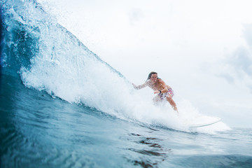 Naklejka premium Surfer rides the ocean wave in tropics