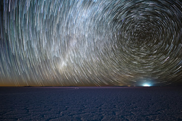 Salar de Uyuni salt flat under night starry sky with star trails like a comets. Altiplano, Bolivia