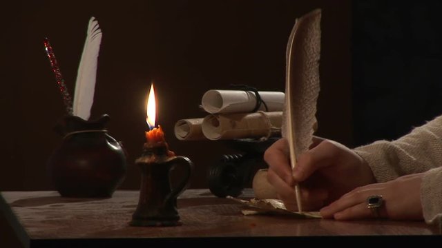 Close-up of a hand as it writes a letter on a paper.