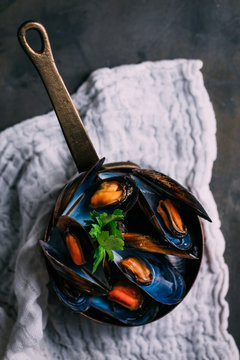Overhead view of boiled mussels served in sauce pan