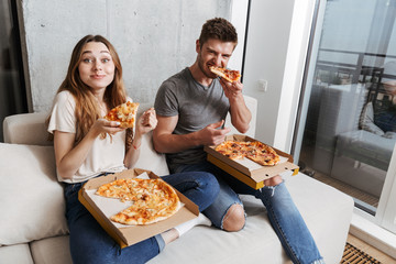 Satisfied young couple eating pizza