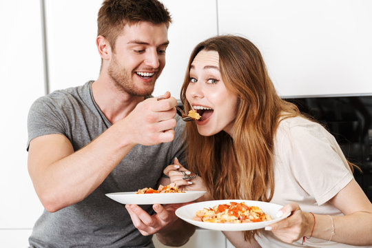 Cheerful young couple eating breakfast