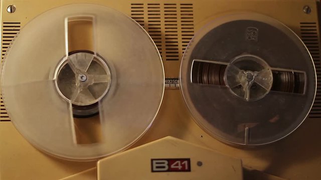 Playing a reel tape on an old tape recorder.