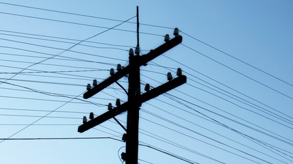 old wooden electric pole with linear insulators and electrical wires. 